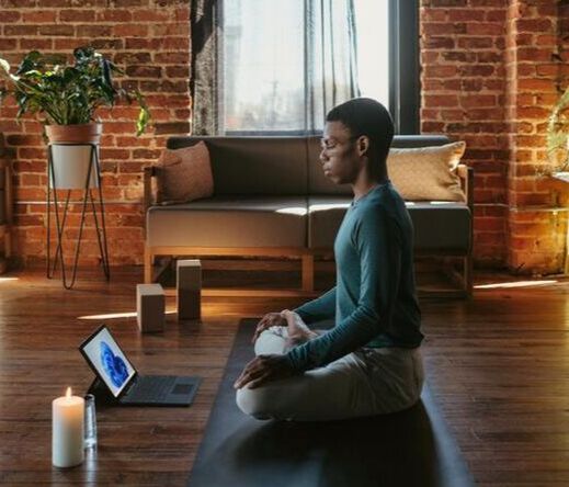Man meditating in front of laptop computer